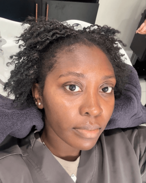 Selfie of Black women getting her hair washed at salon.